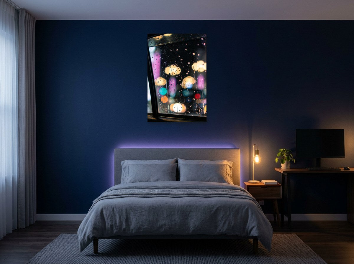 Mise en situation numérique : la toile Vitre de taxi au-dessus d’un lit gris, sur le mur bleu nuit d’une chambre éclairée le soir par une lampe de chevet