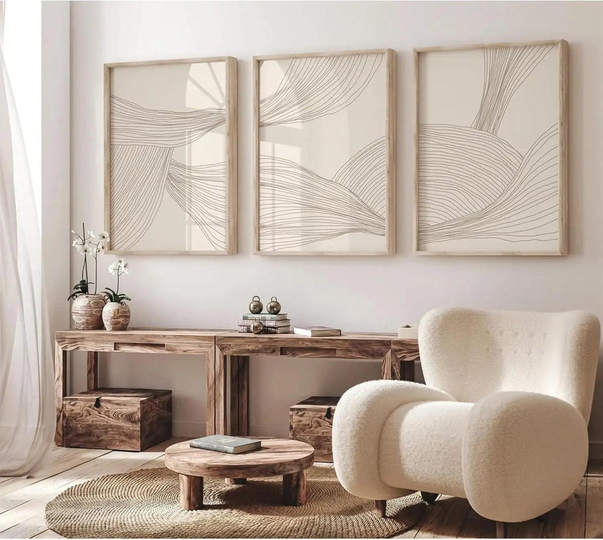 Trois affiches à fines lignes taupe sur fond beige, encadrées au-dessus d’une console en bois et d’un fauteuil bouclette