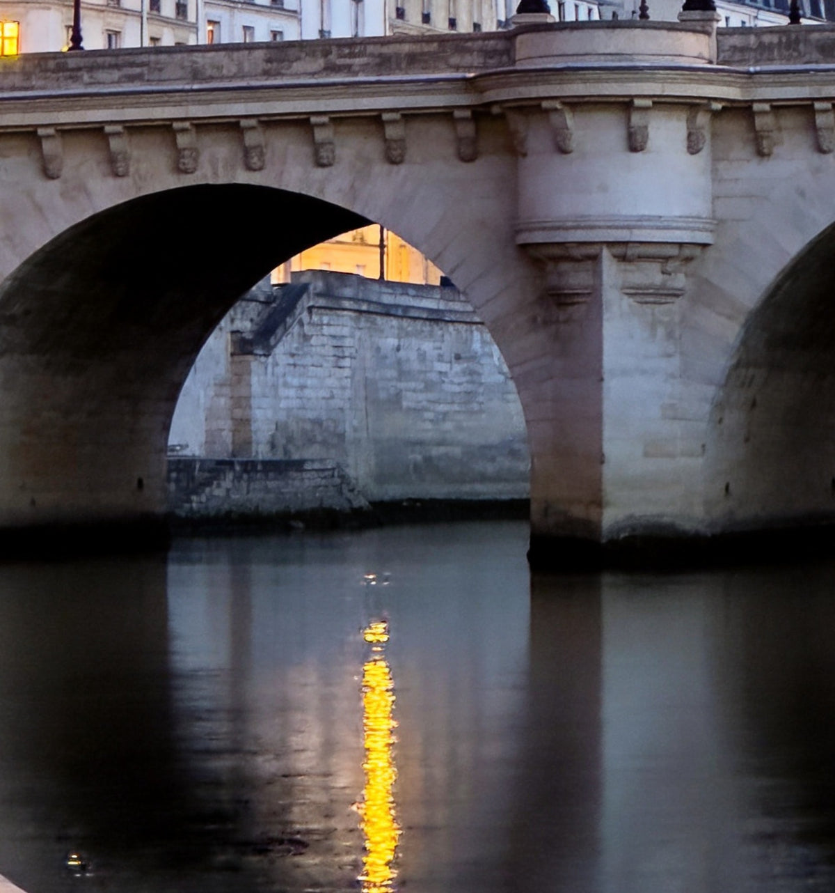 Détail : arche et pile en demi-lune d'un vieux pont de pierre, reflets dorés sur l'eau