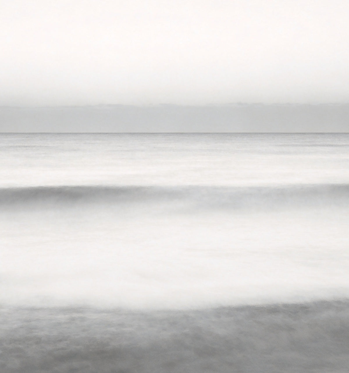Détail : l'horizon et la mer adoucie par la pose longue, en bandes de gris perle