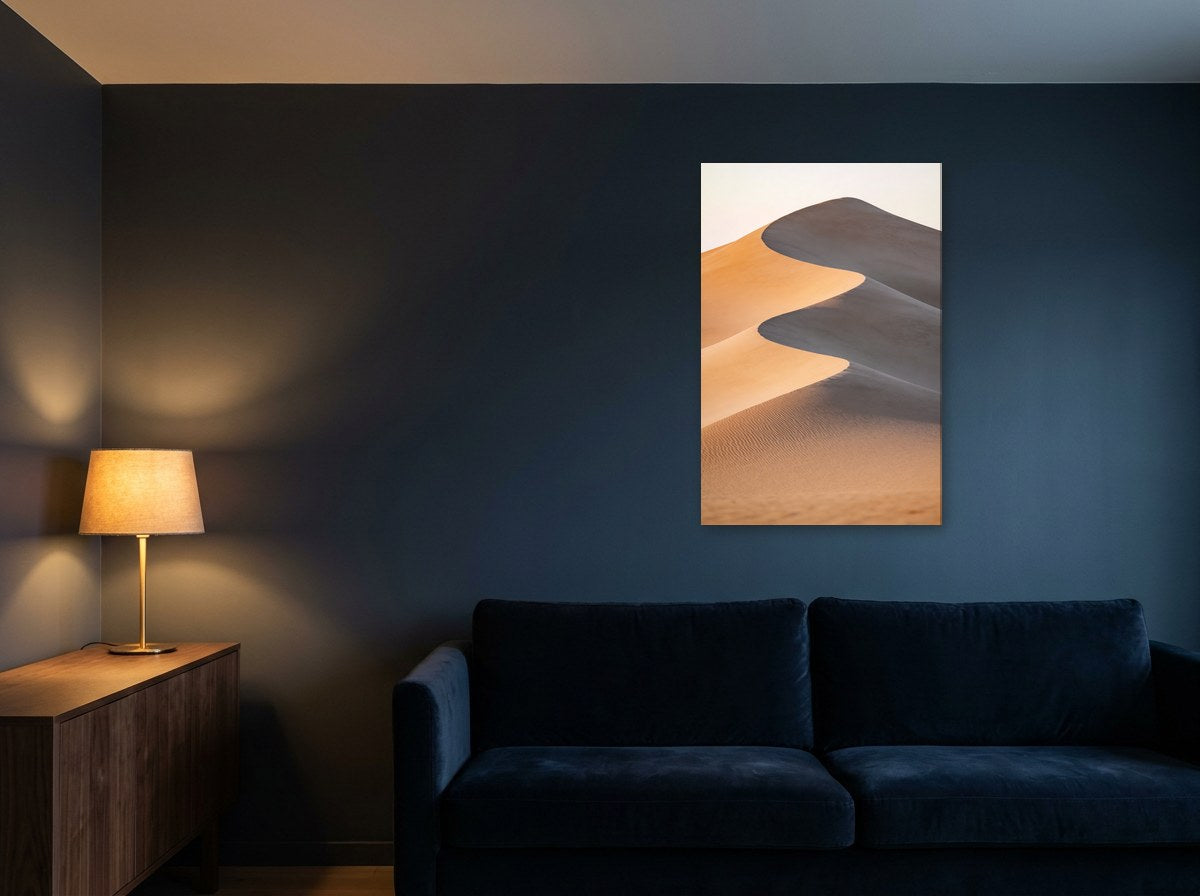 Mise en situation : toile « Dunes pâles » au-dessus d'un canapé en velours bleu marine, sur un mur bleu nuit éclairé par une lampe