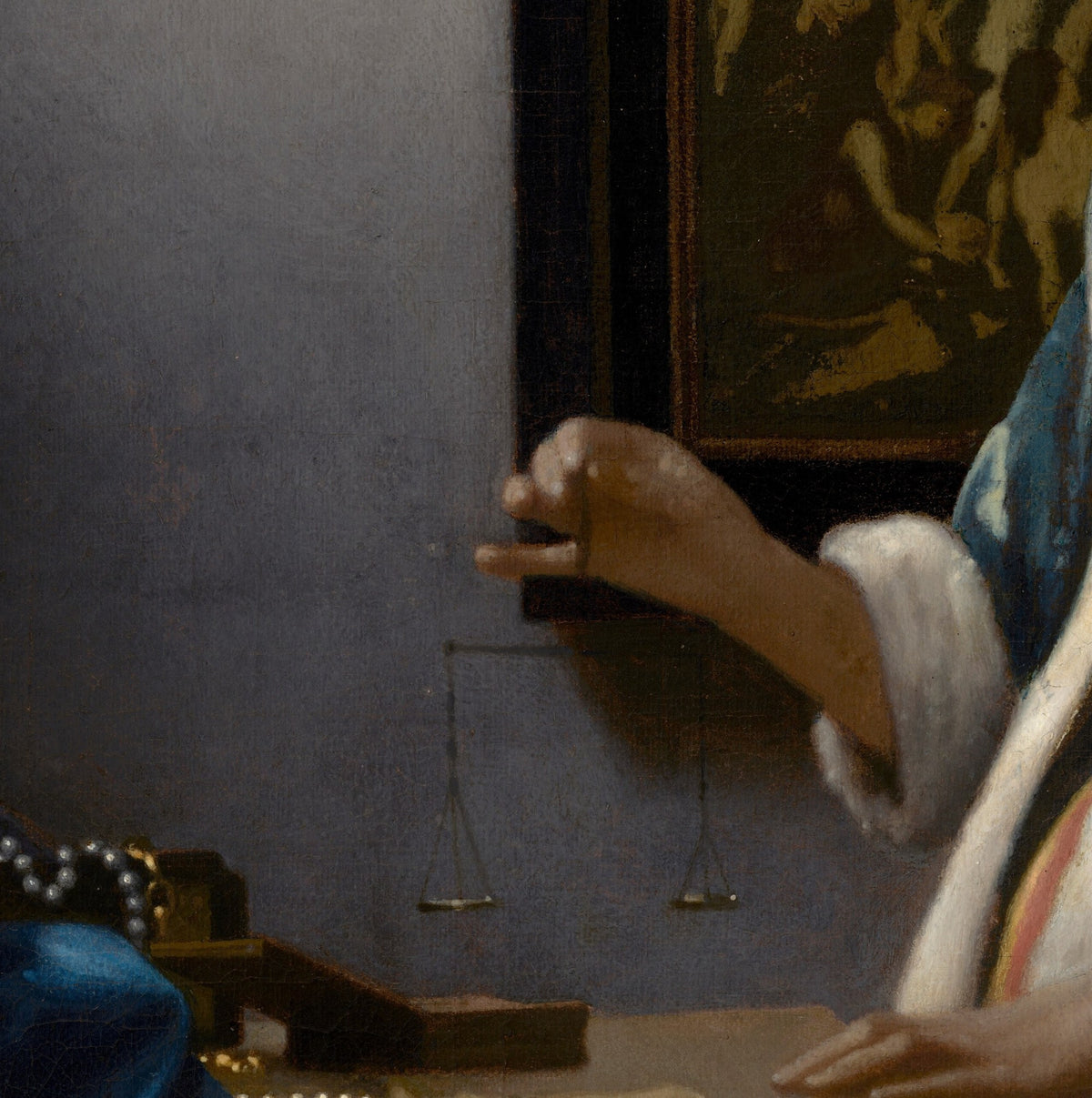 Détail de La Femme à la balance (Vermeer) : main tenant la balance aux plateaux vides, perles sur un coffret ouvert