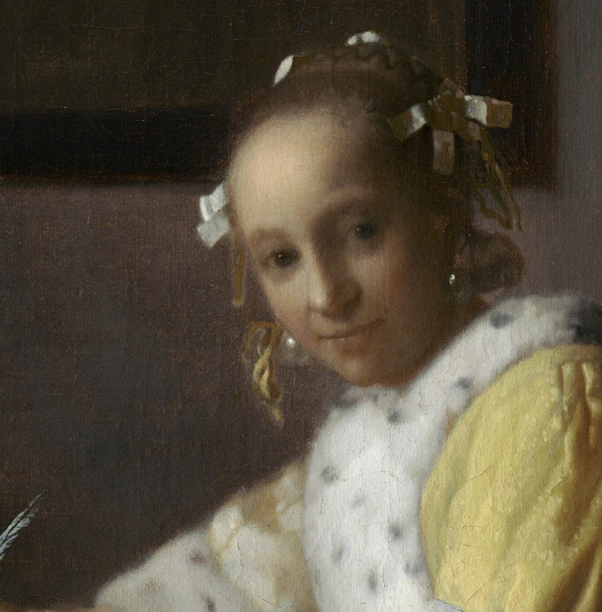Détail de Jeune Femme écrivant une lettre (Vermeer) : visage tourné vers nous, rubans dans les cheveux, perle à l'oreille